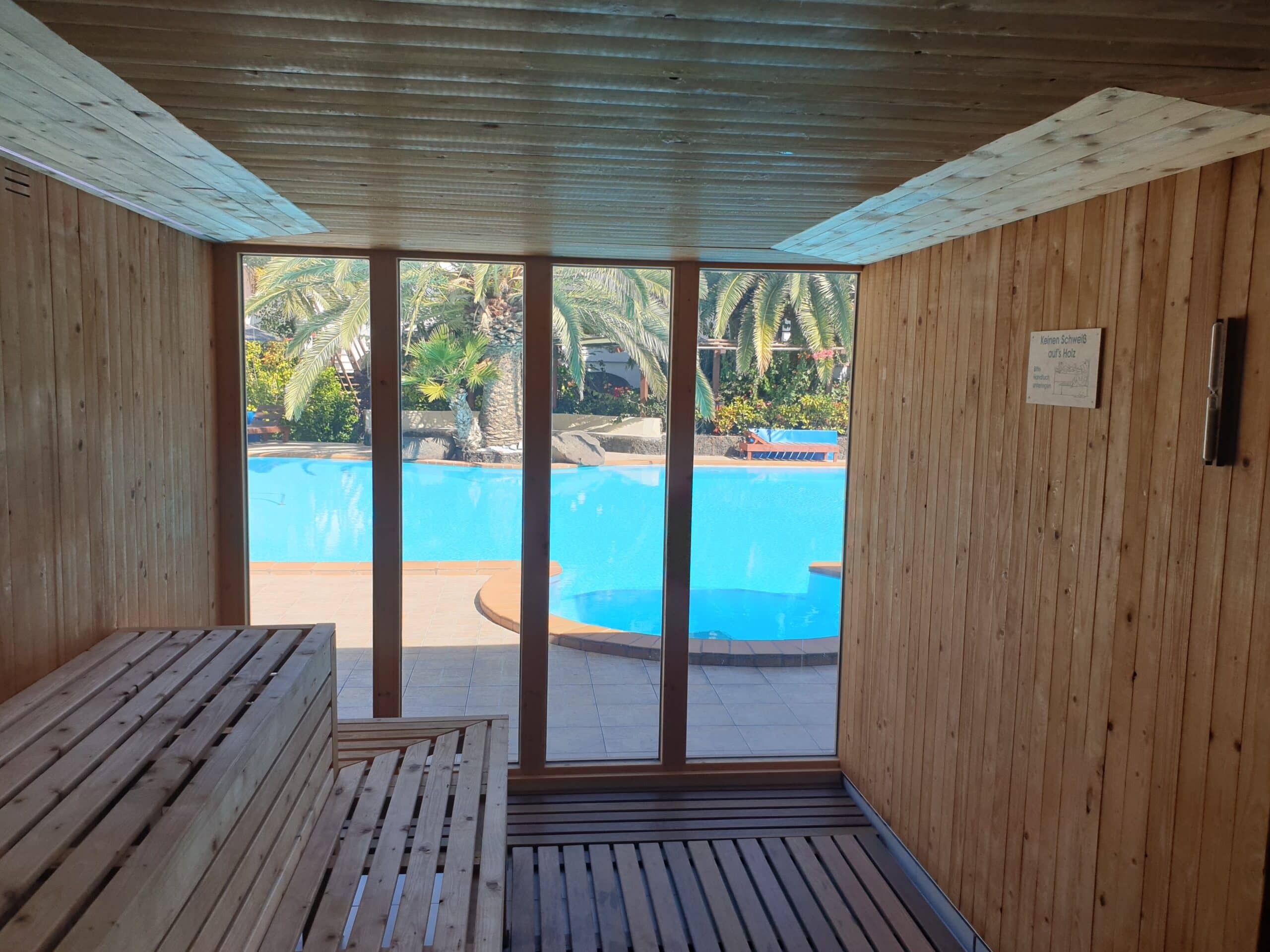 Sicht aus Sauna auf Pool&Whirlpool mit Baenken